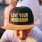 man with a baseball cap sitting outdoors