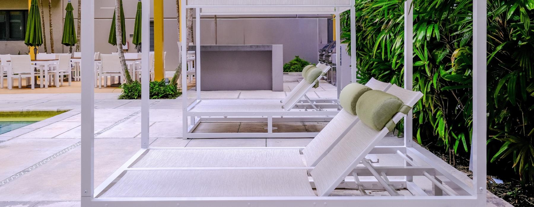 white lounge chairs by a pool