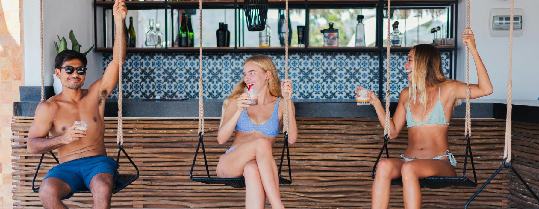 a group of people sitting on swings eating ice cream